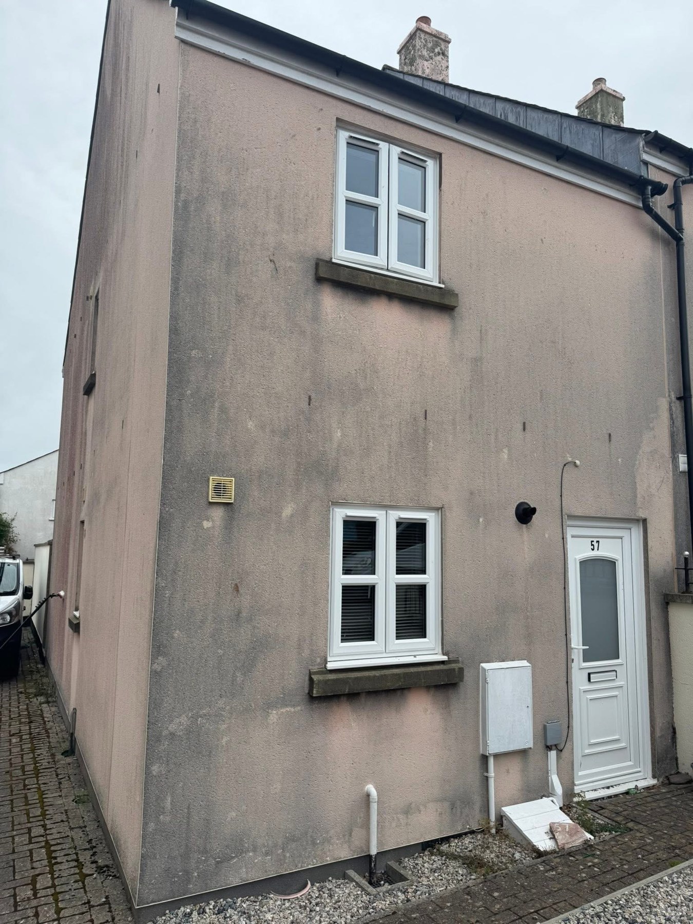 Pink rendered house before exterior cleaning